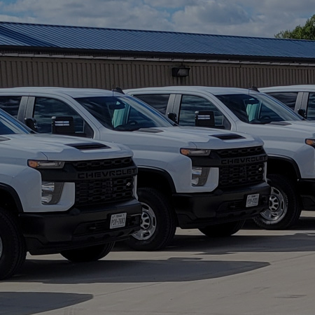 Row of white Chevrolet trucks